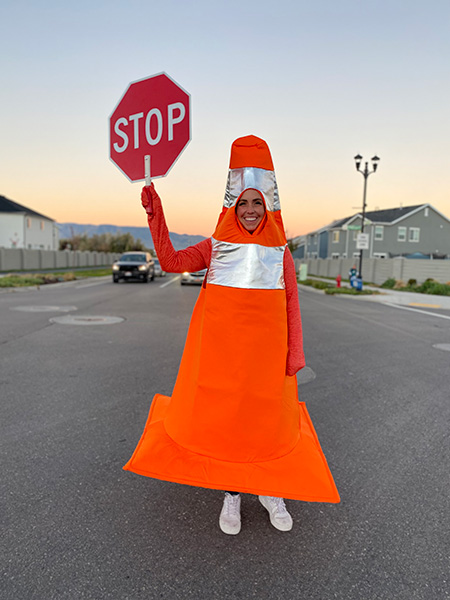 Mom dressed as traffic cone holding stop sign