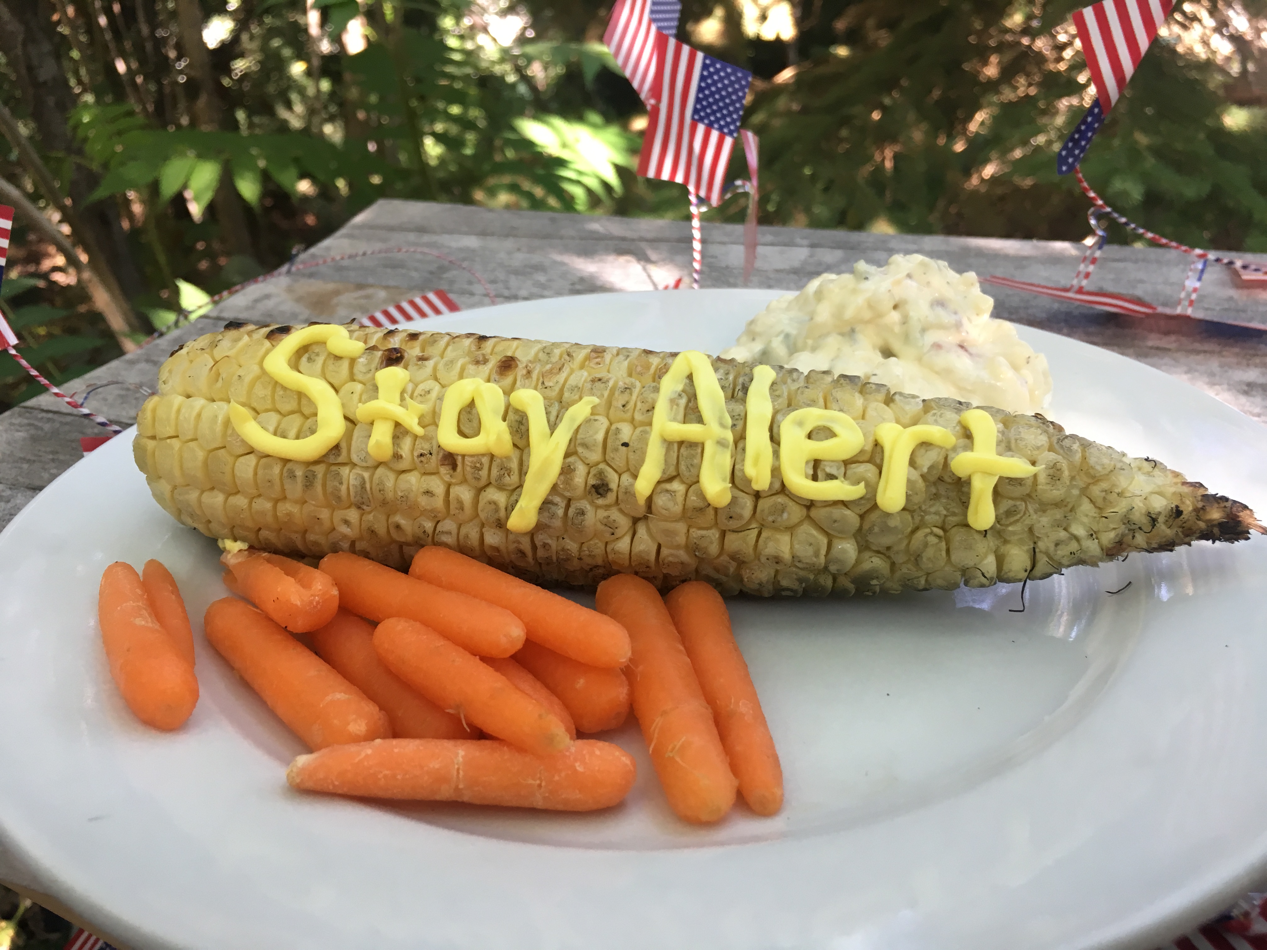 Corn on the cob with the message Stay Alert written in butter