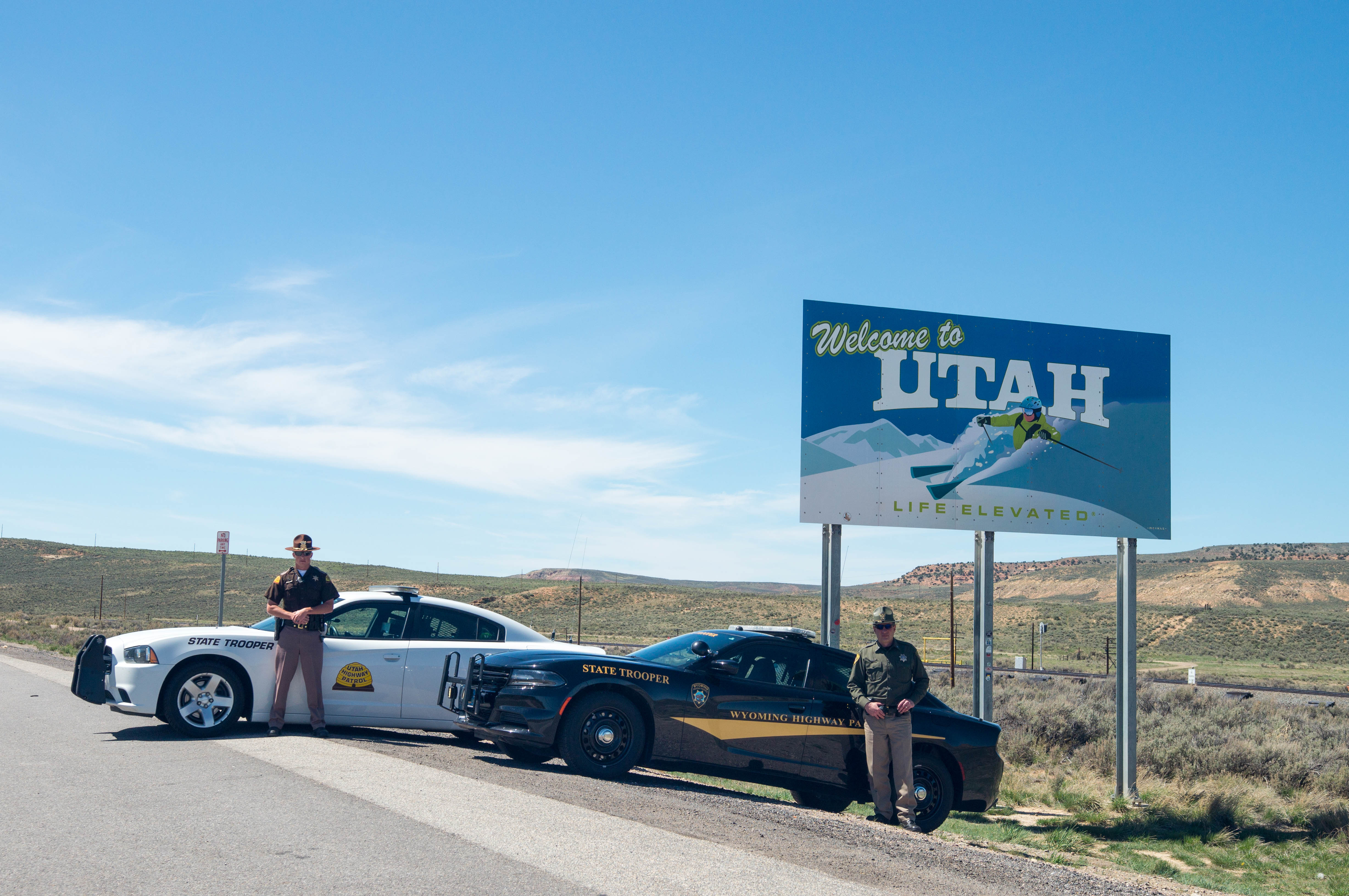 UHP Trooper and WHP Trooper by the welcome to Utah sign outside of Evanston