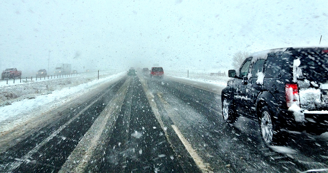 Cars driving on a snowy road. When there's ice and snow, take it slow