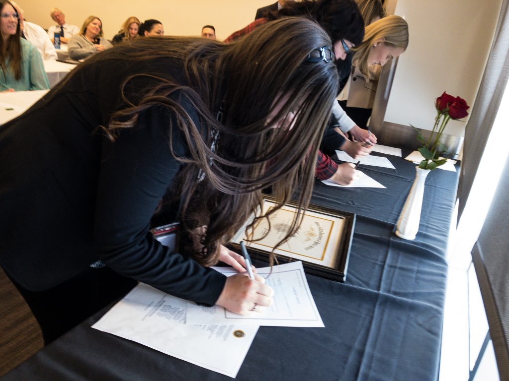 New employees sign their oath of office paper work.