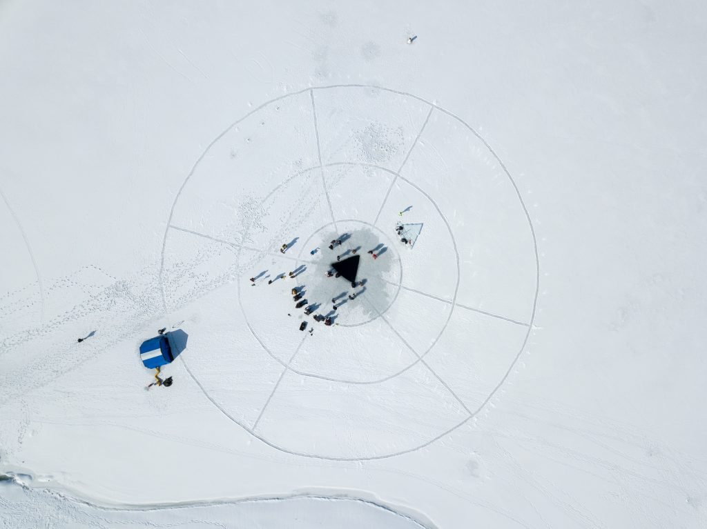 Aerial shot shows the triangle cut in the ice for ice diving training at Deer Creek Reservoir.