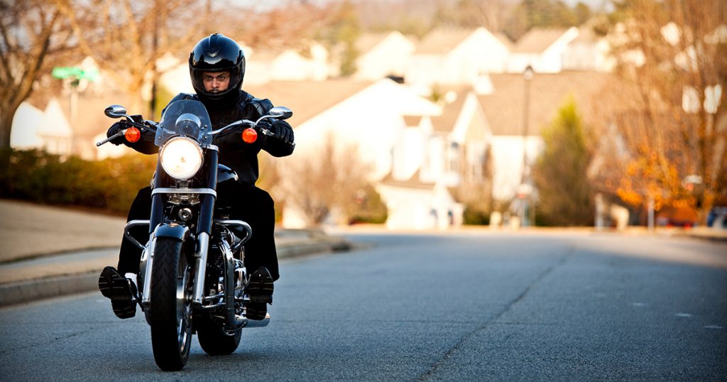 A motorcyclist rides down the street.