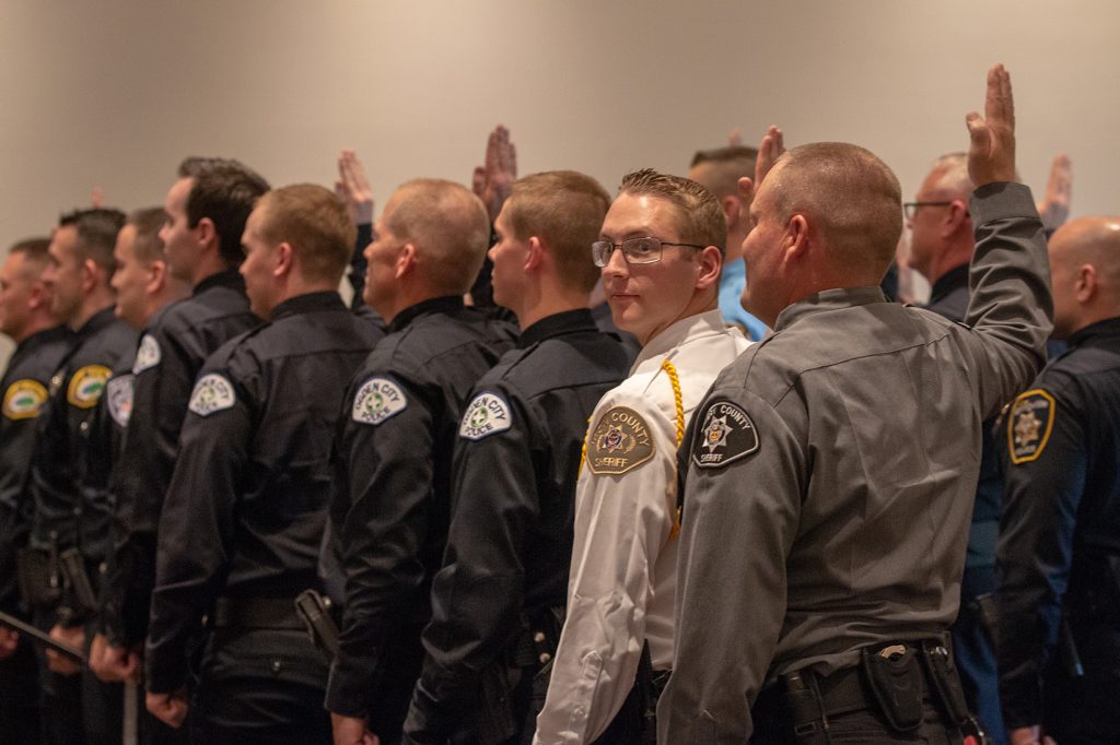 The cadets raise their right hands for the code of ethics.