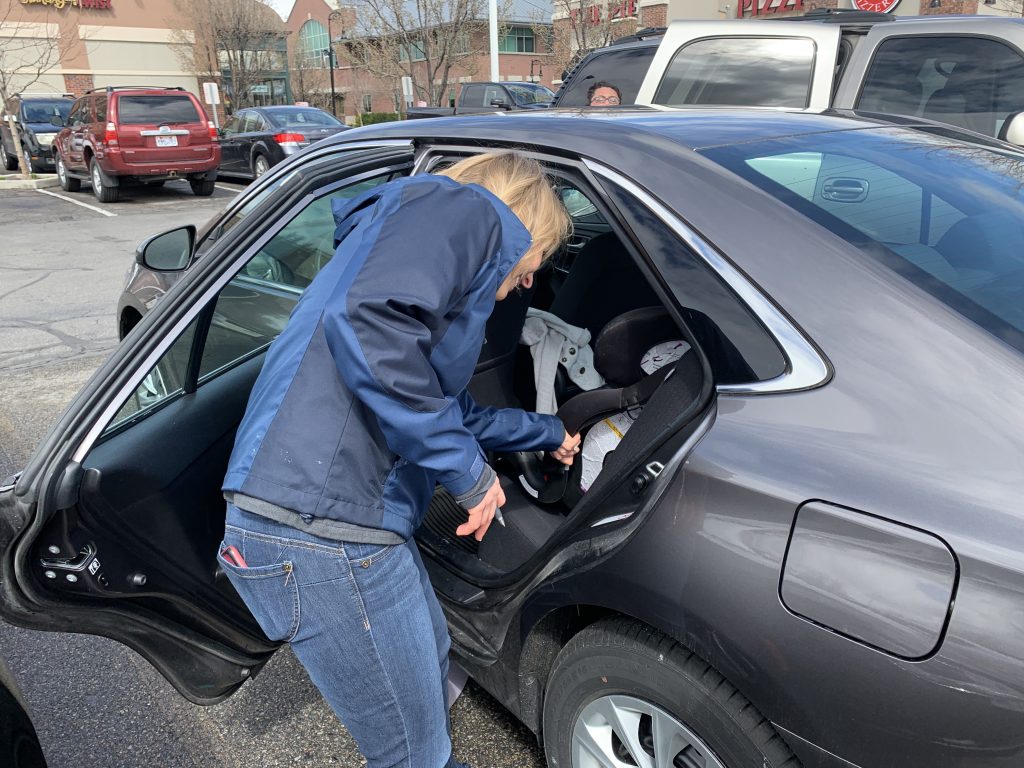 CPS Instructor checking on the installation of a car seat.