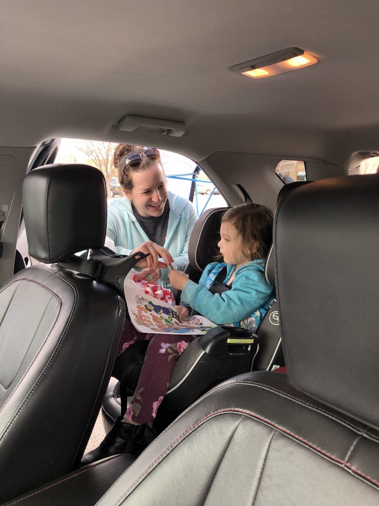 After checking a car seat, a technician gives a child a sticker.