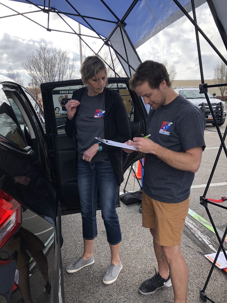 Technicians complete paper work at a car seat check point.