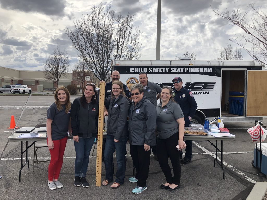 Car seat technicians pose for a group photo at a car seat check point.