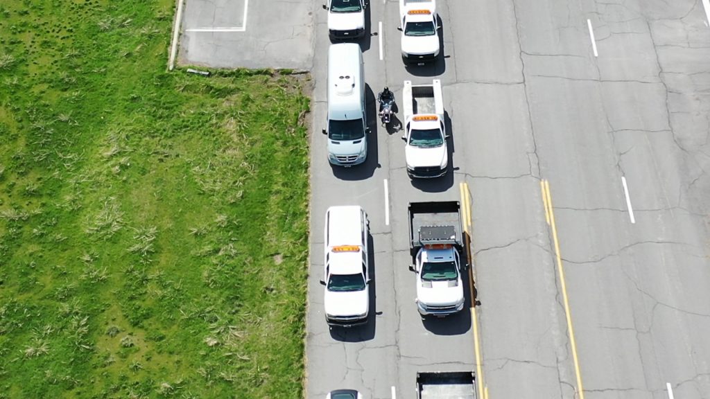 Motorcycle lane filtering between two lanes of stopped traffic.